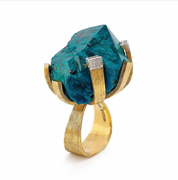 Dioptase mounted in yellow gold and framed by baguette diamonds ring by Andrew Grima. Image Courtesy of F. Grima